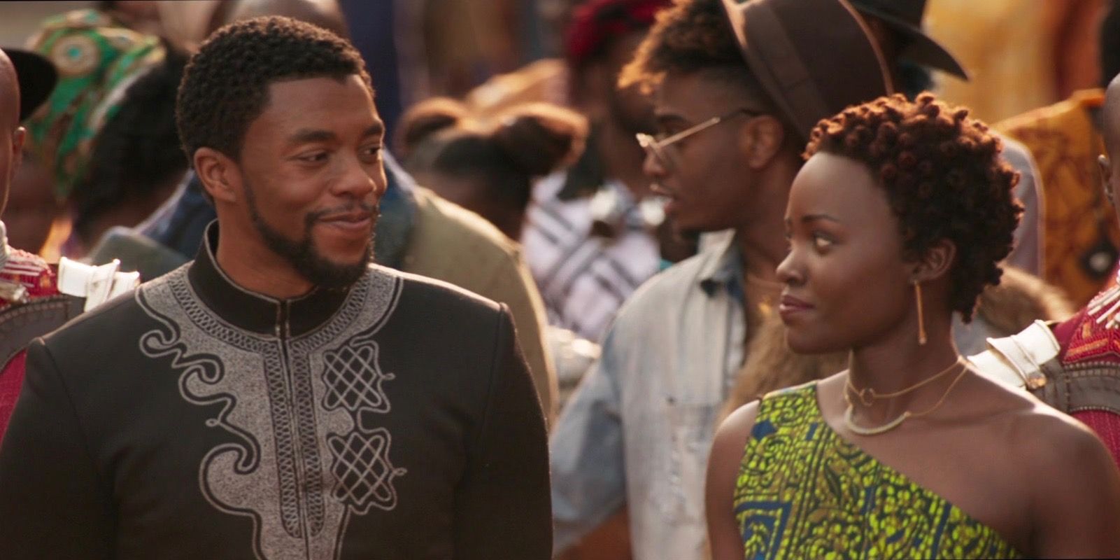 Chadwick Boseman and Lupita Nyong'o as T'Challa and Nakia in Black Panther walk in the Wakandan market.