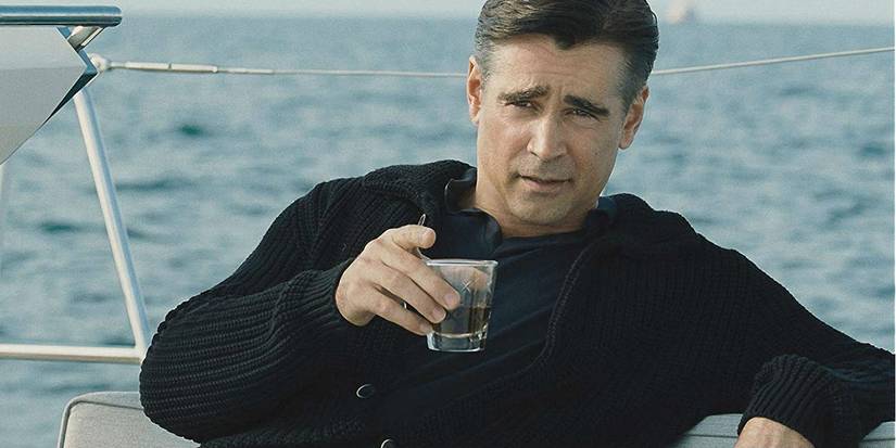 Colin Farrell as Jim Mulligan holding a drink on a boat in Widows