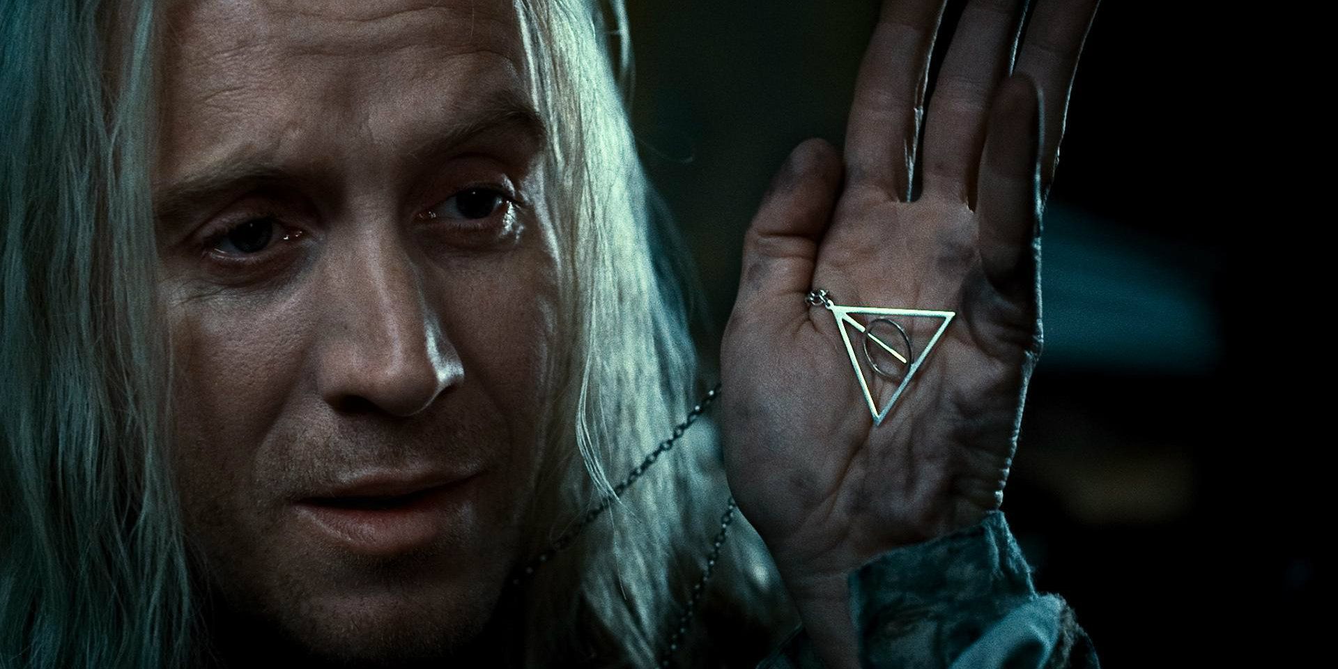 Xenophilius Lovegood holding up the deathly hallows sign necklace