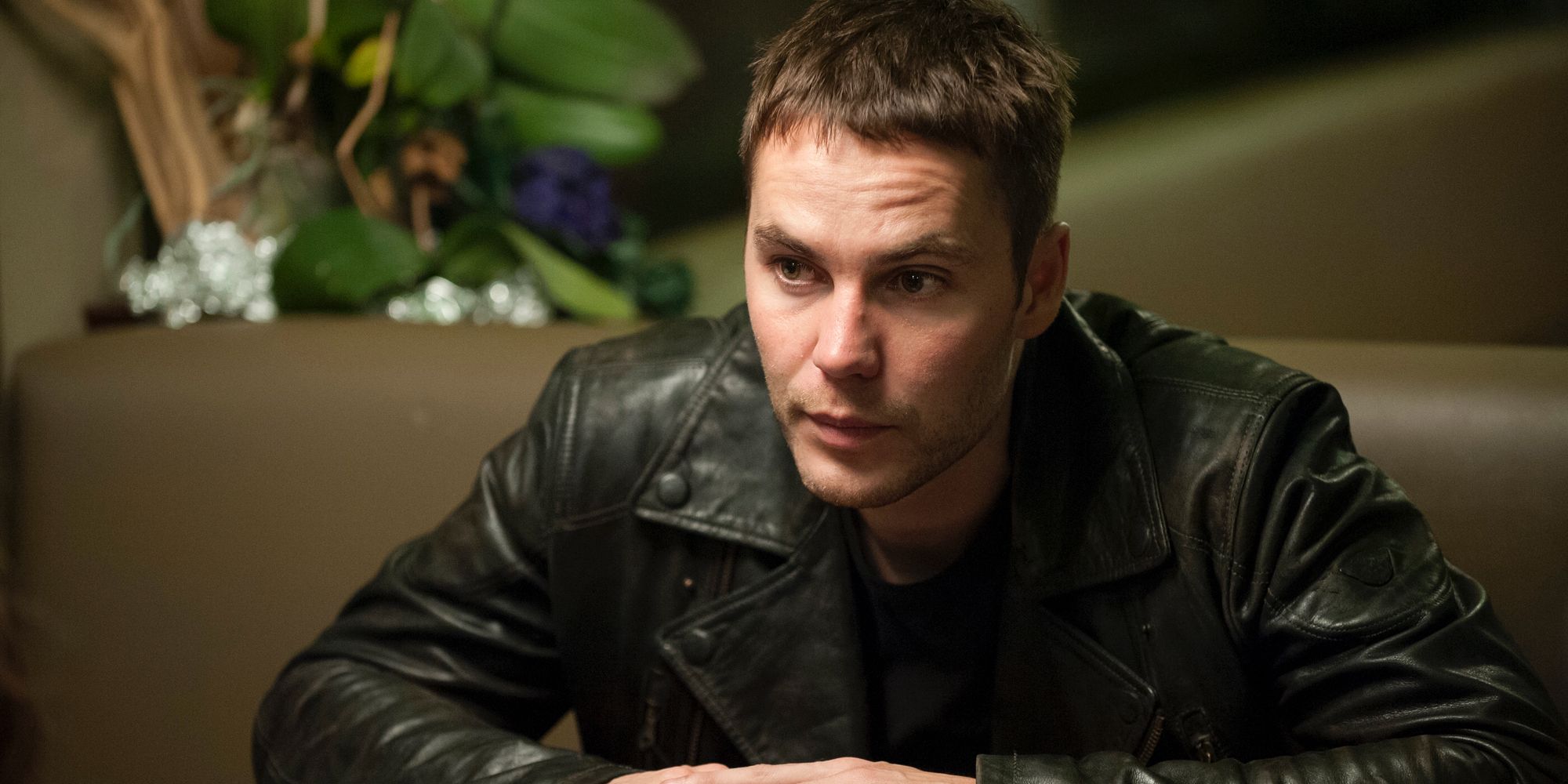Paul, de Taylor Kitsch, está sentado em uma mesa parecendo preocupado na segunda temporada de True Detective