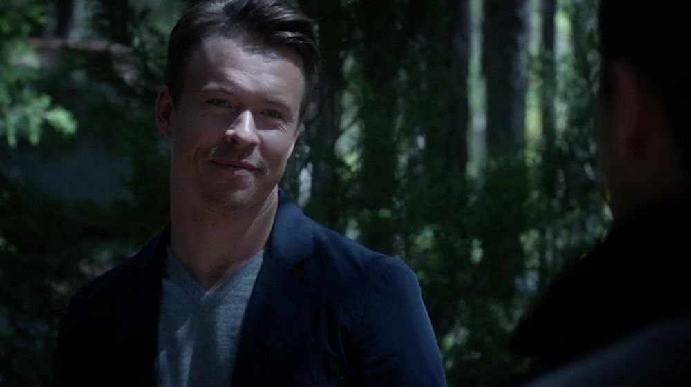 Julian in The Vampire Diaries looks at someone in the dark woods.