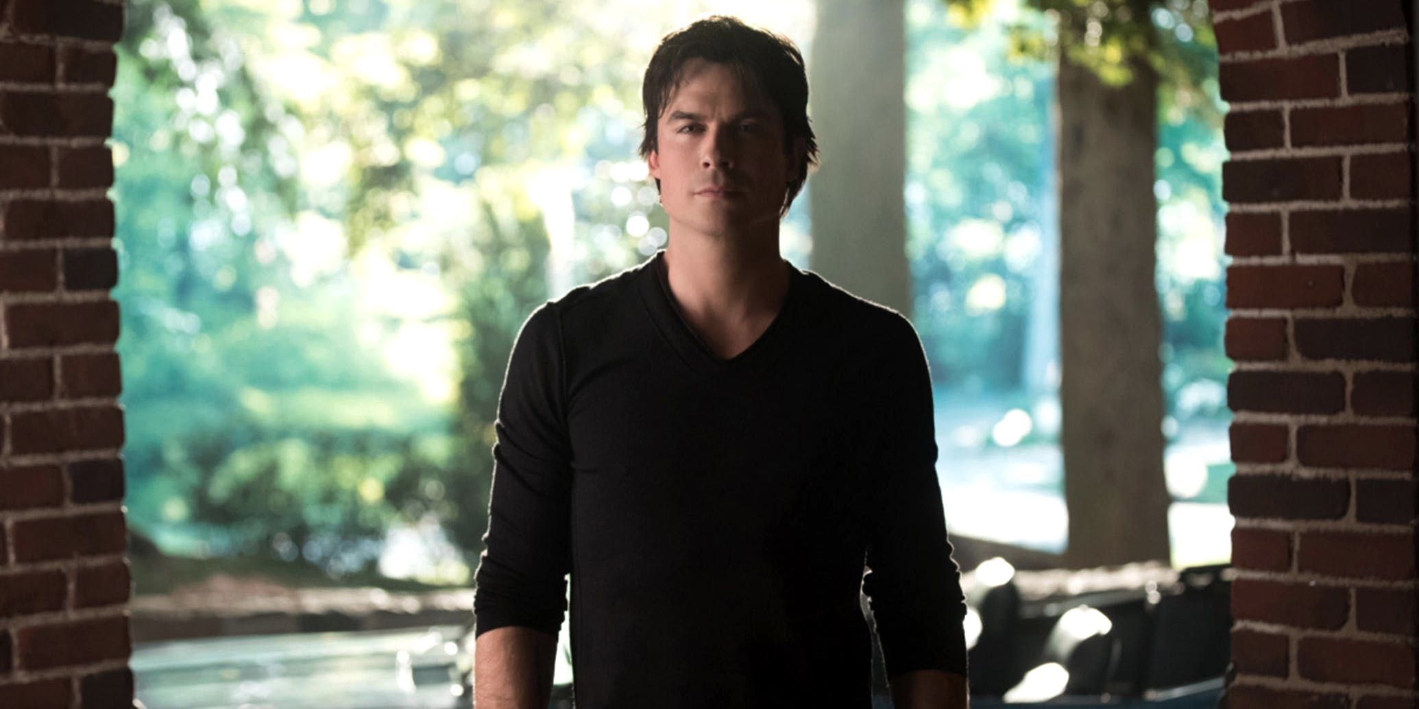 Damon parado em uma varanda olhando em The Vampire Diaries.