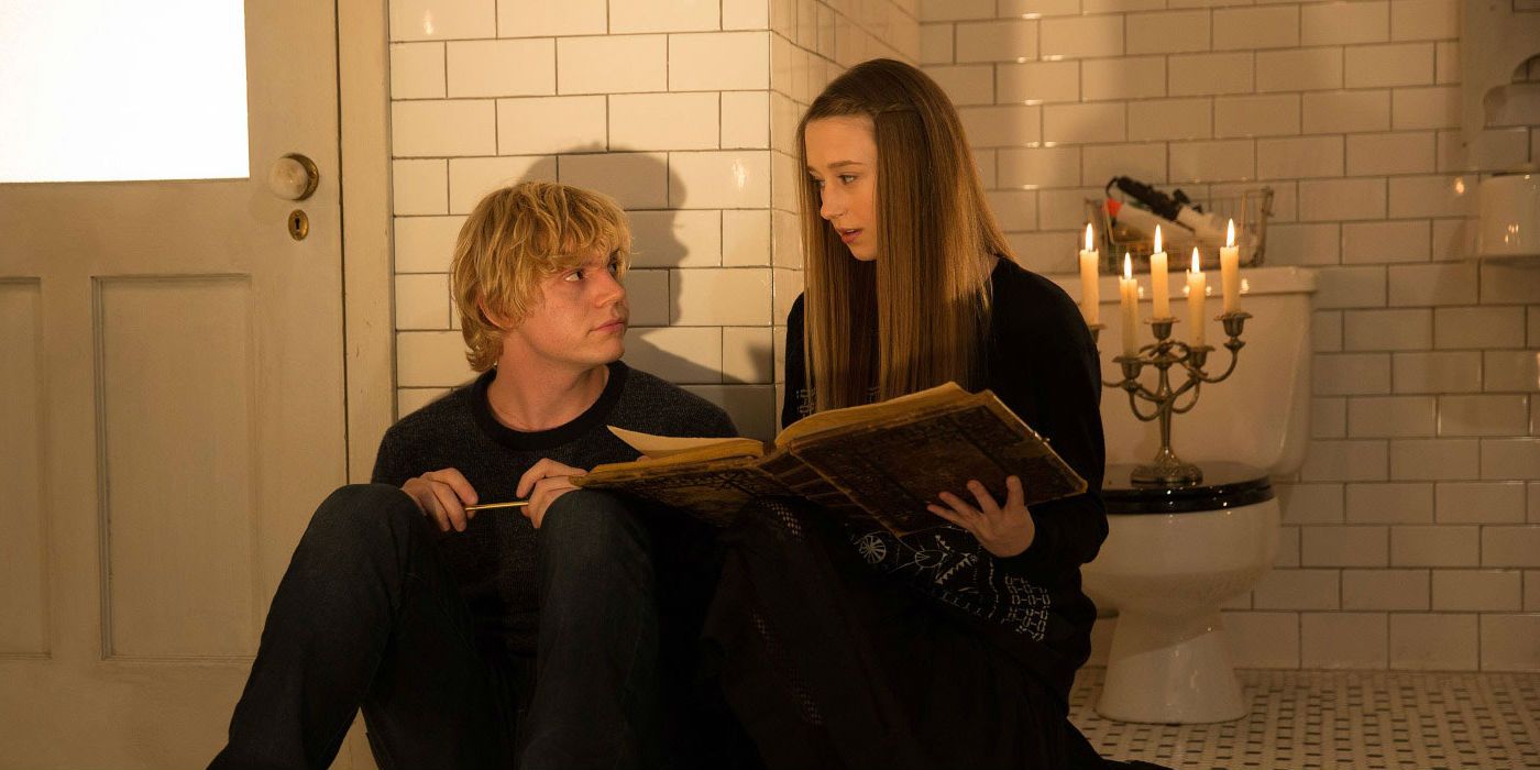 Zoe reading a book with Kyle beside her in AHS Coven