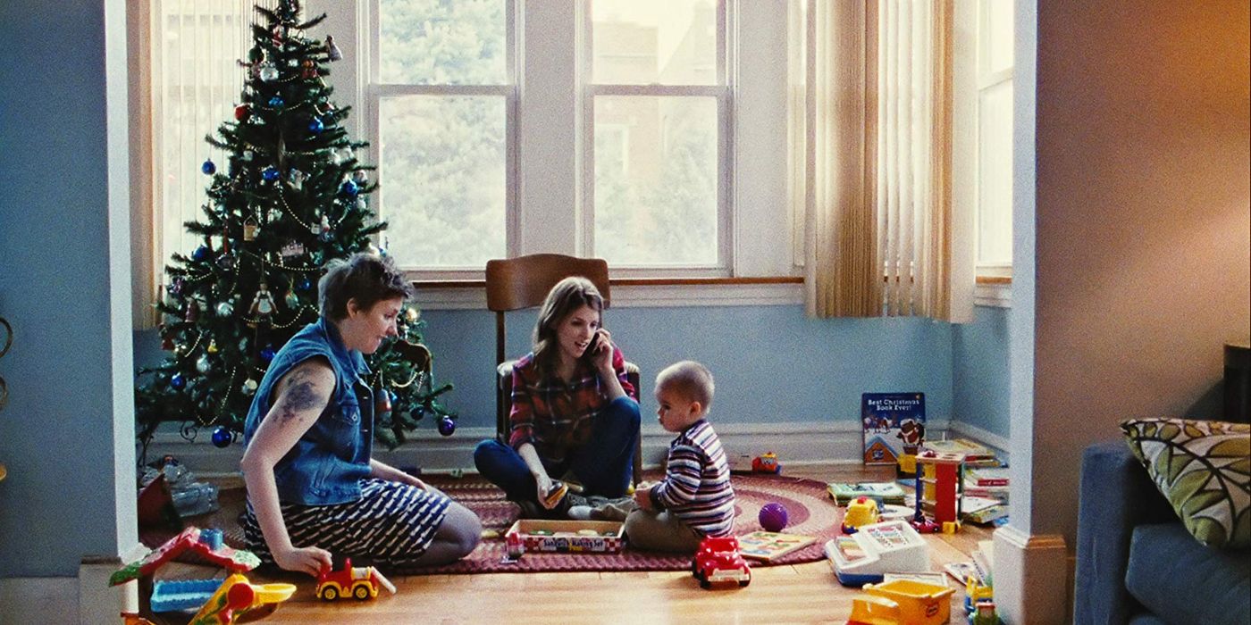 Carson, Jenny and a toddler sitting on the floor in Happy Christmas