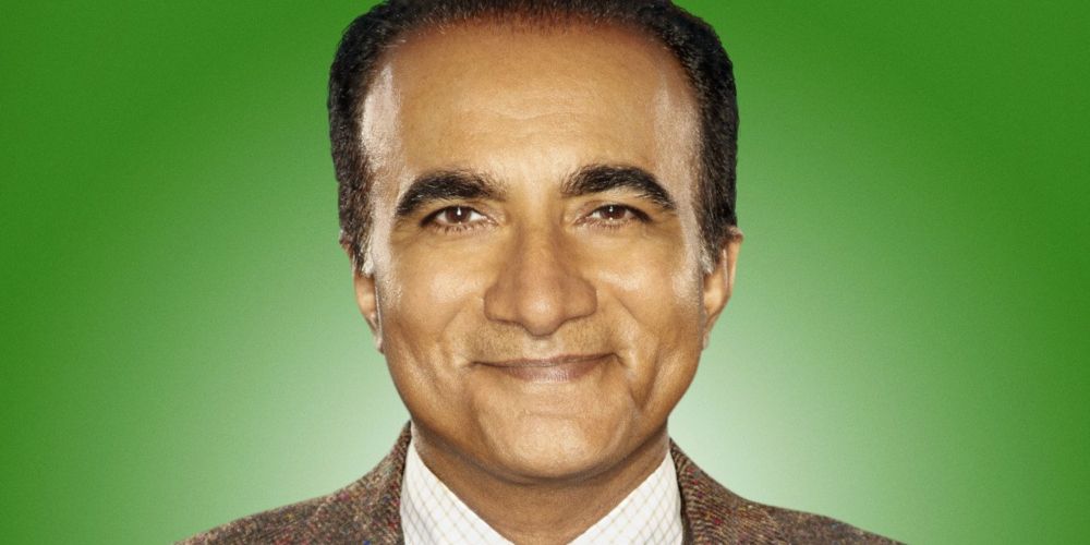 Principal Figgins smiling against a green background in Glee