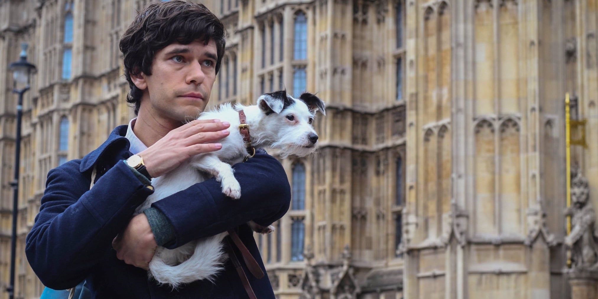 Ben Whishaw holding a dog in A Very English Scandal