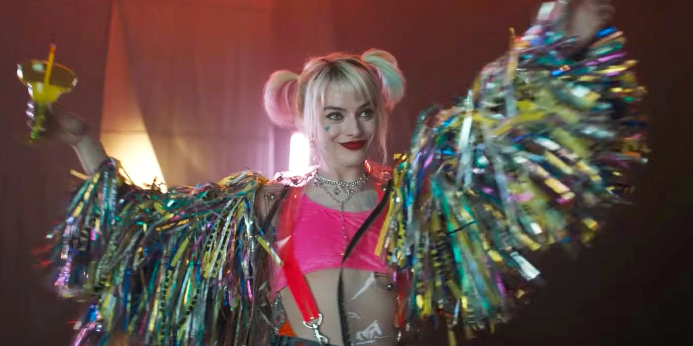 Harley Quinn em aves de rapina segurando uma bebida e usando serpentinas nos braços