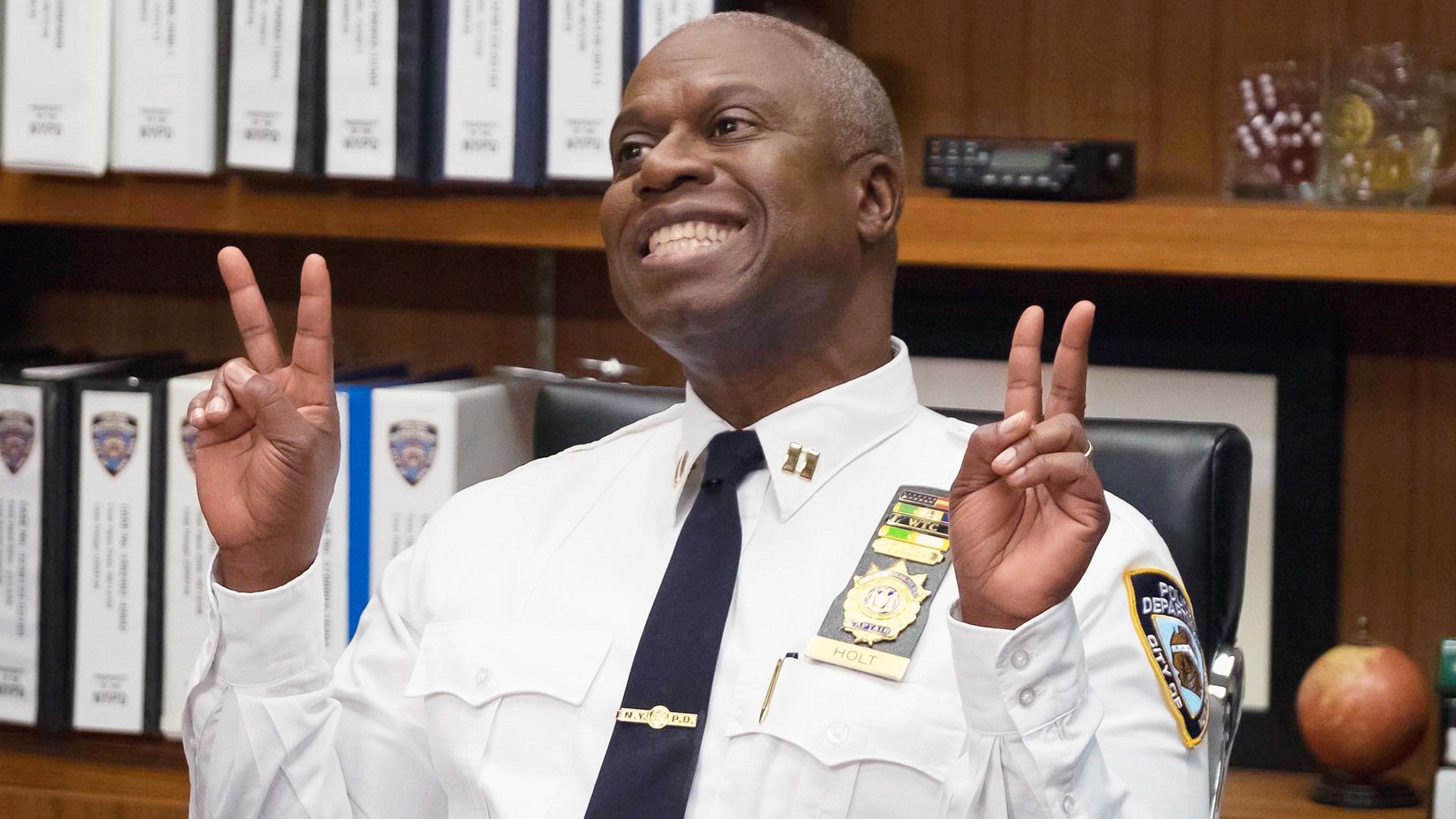 Captain Holt smiling and peacing out