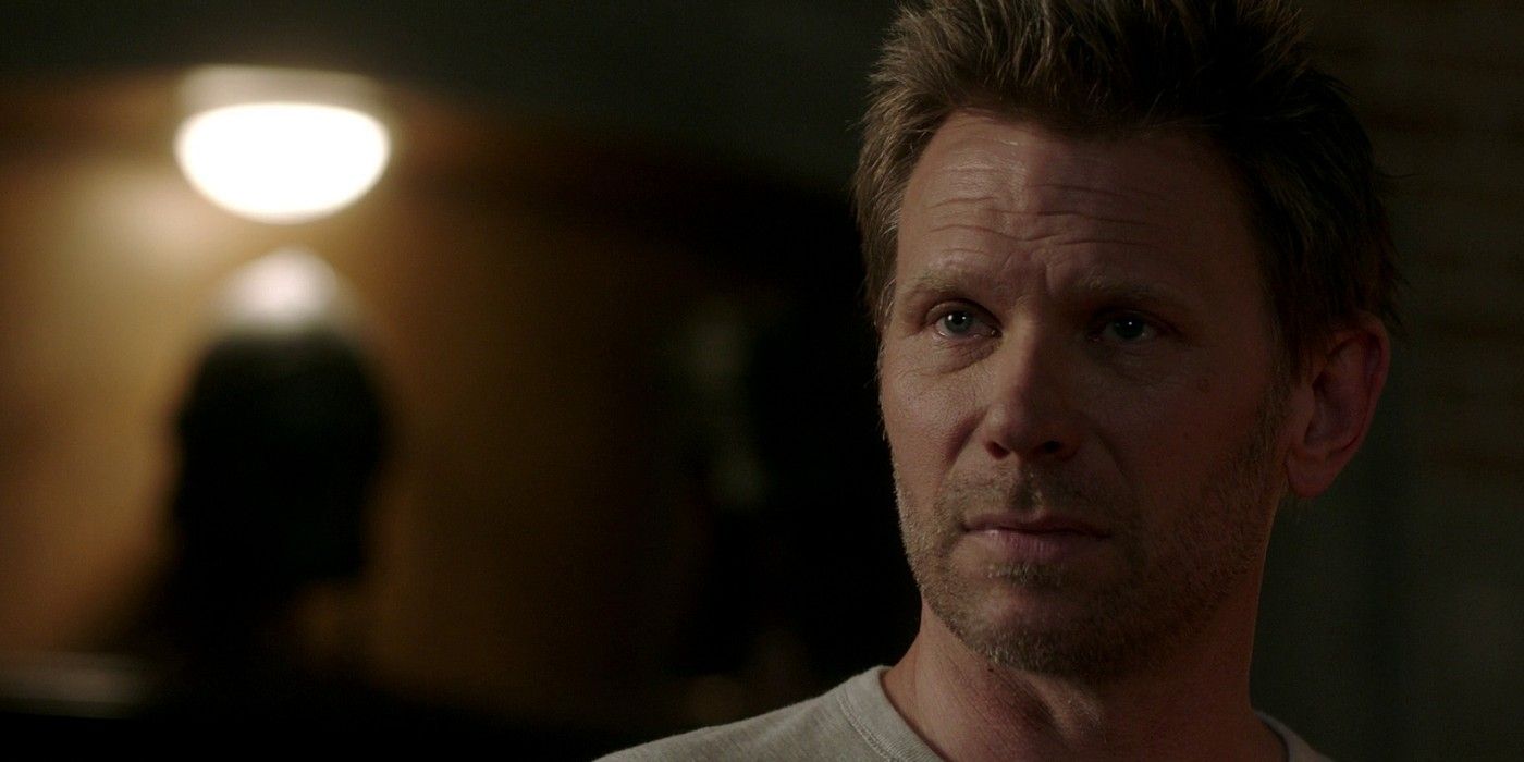 Mark Pellegrino as Lucifer Nick in Supernatural in a solo shot looking towards the camera. He is partially obscured by darkness