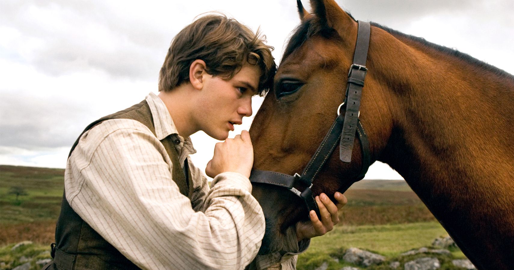 A man hugging and talking to his horse in a still from War Horse