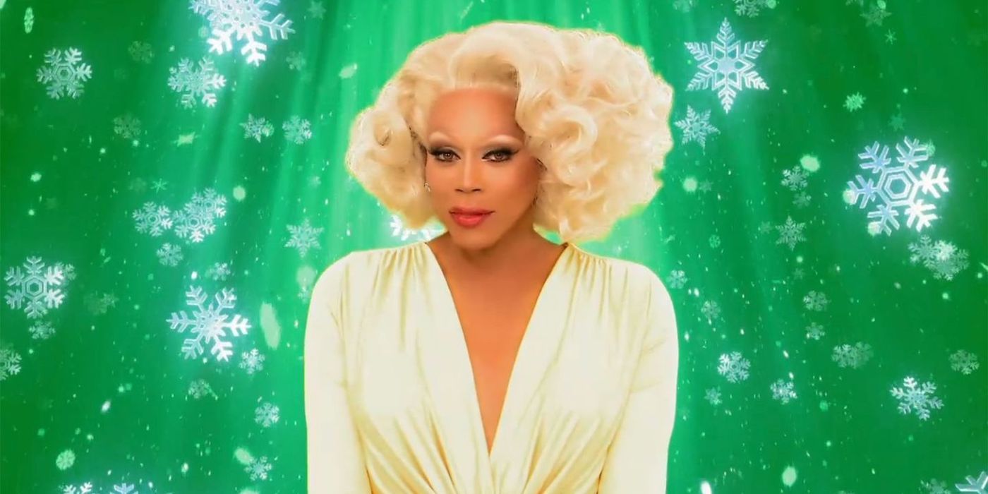 RuPaul standing in front of a green screen with snowflakes.