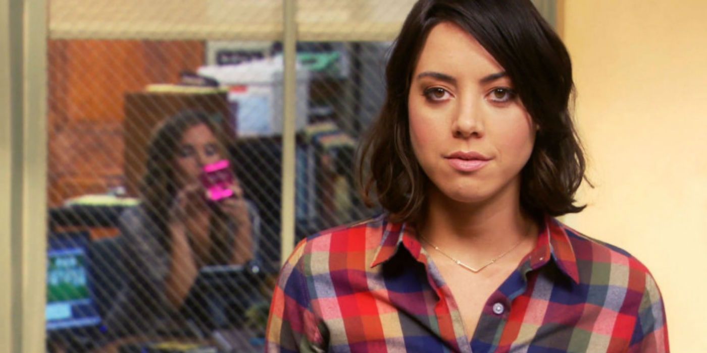 Aubrey Plaza as April Ludgate in Parks and Recreation standing in front of window