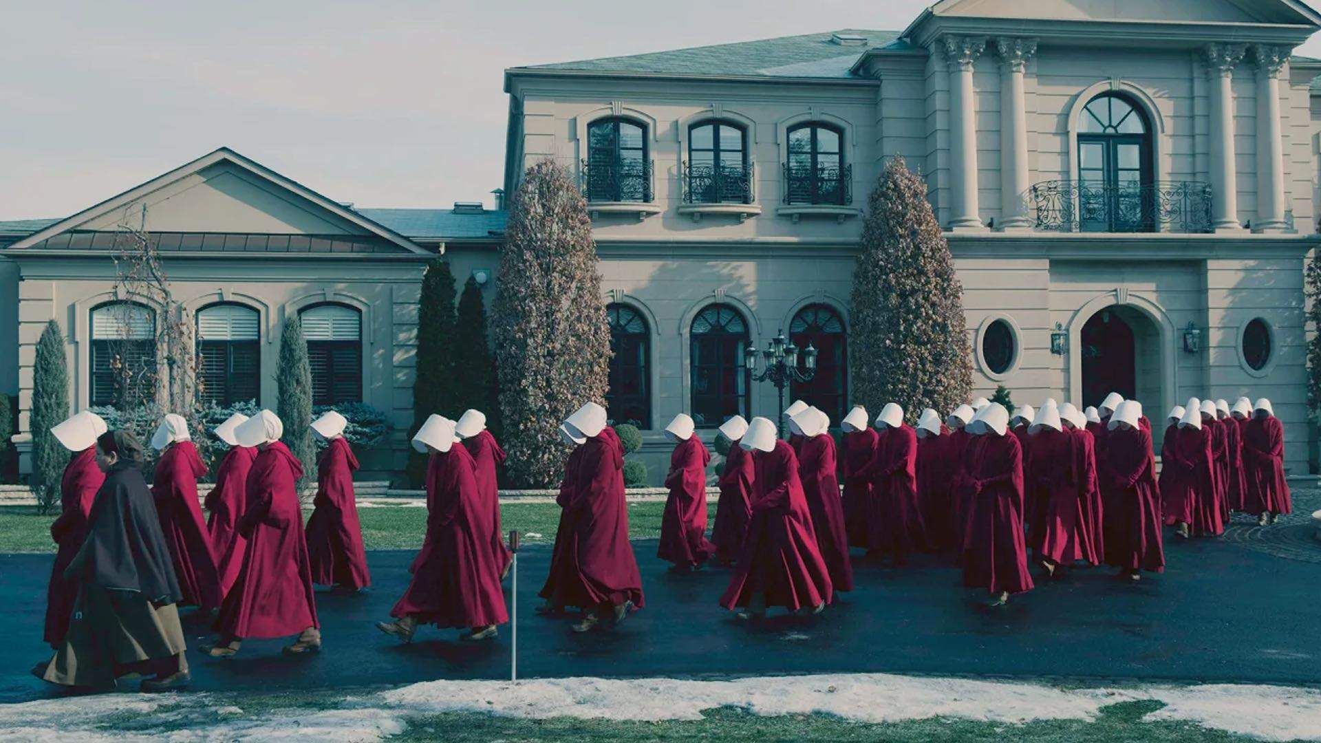 The Handmaids walk past a building in The Handmaid’s Tale