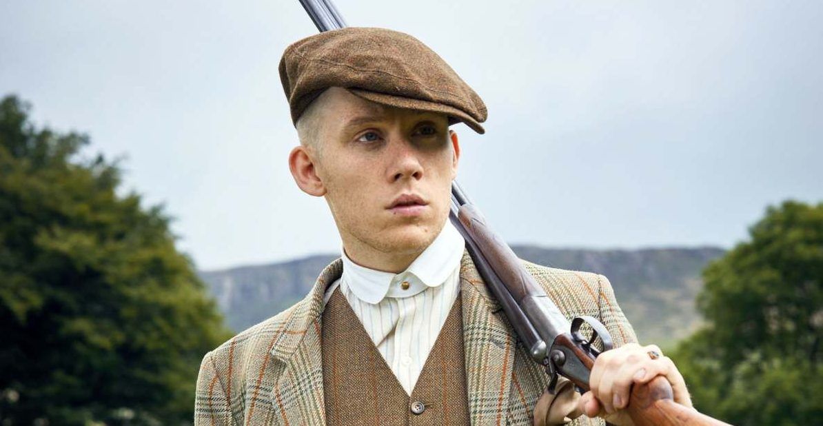 John Shelby from Peaky Blinders with a rifle slung over his shoulder