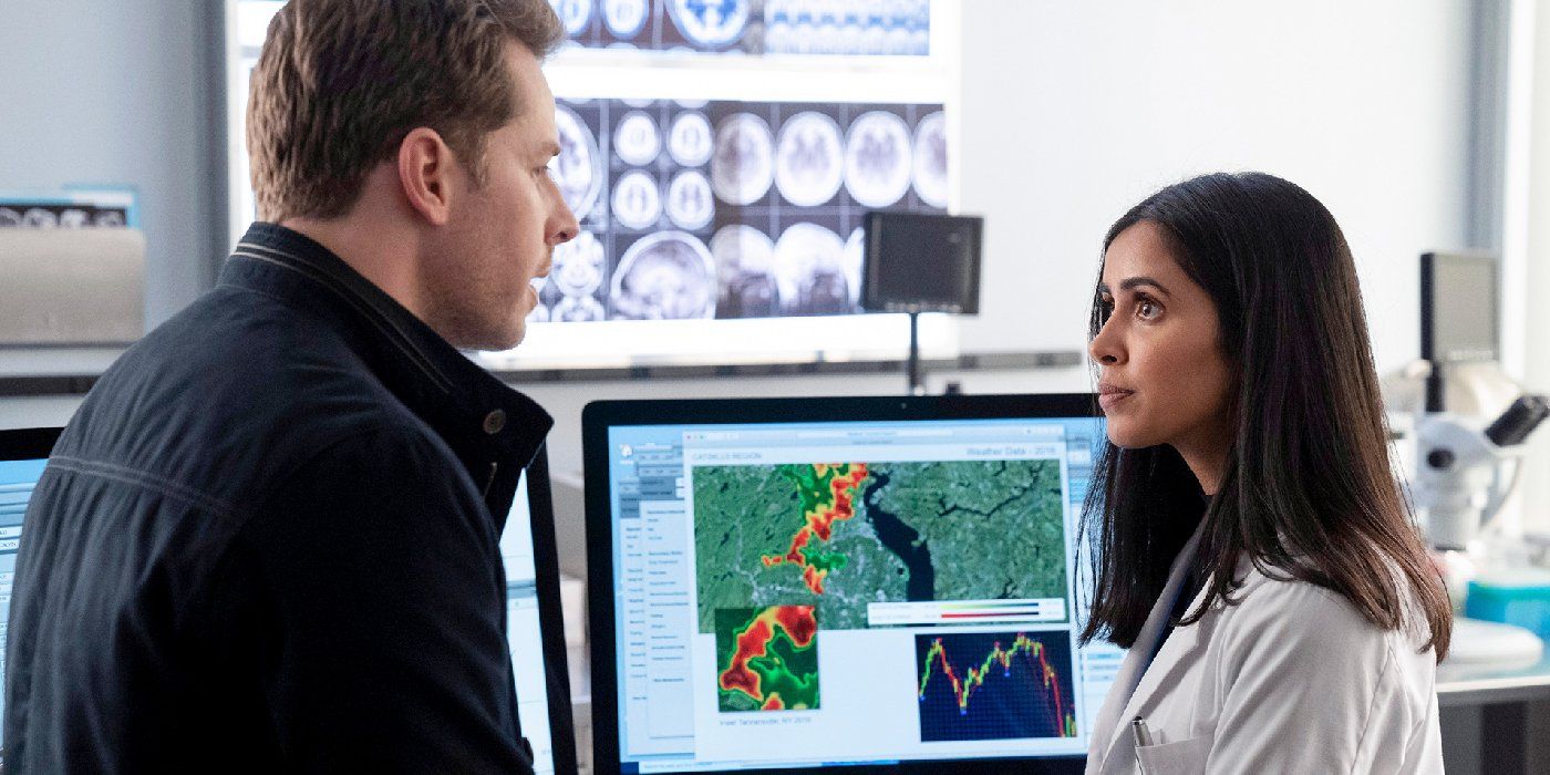 Josh Dallas as Ben Stone talking to Parveen Kaur as Saanvi Bahl by a computer in Manifest.