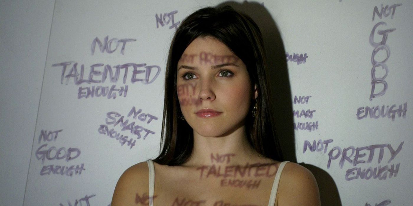 Brooke Davis stands in front of a light projection on One Tree Hill