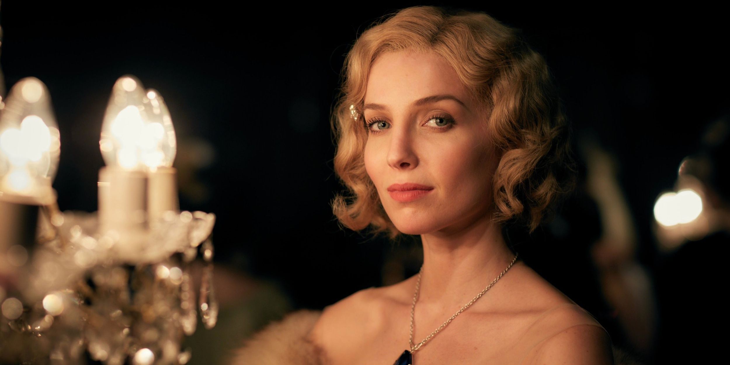 Grace Shelby dari Peaky Blinders tersenyum ke arah kamera dari meja rias