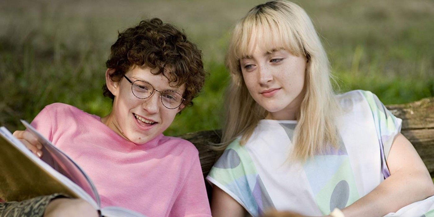 Saiorse Ronan and Tom Holland recline on the grass outside in How I Live Now from 2013.