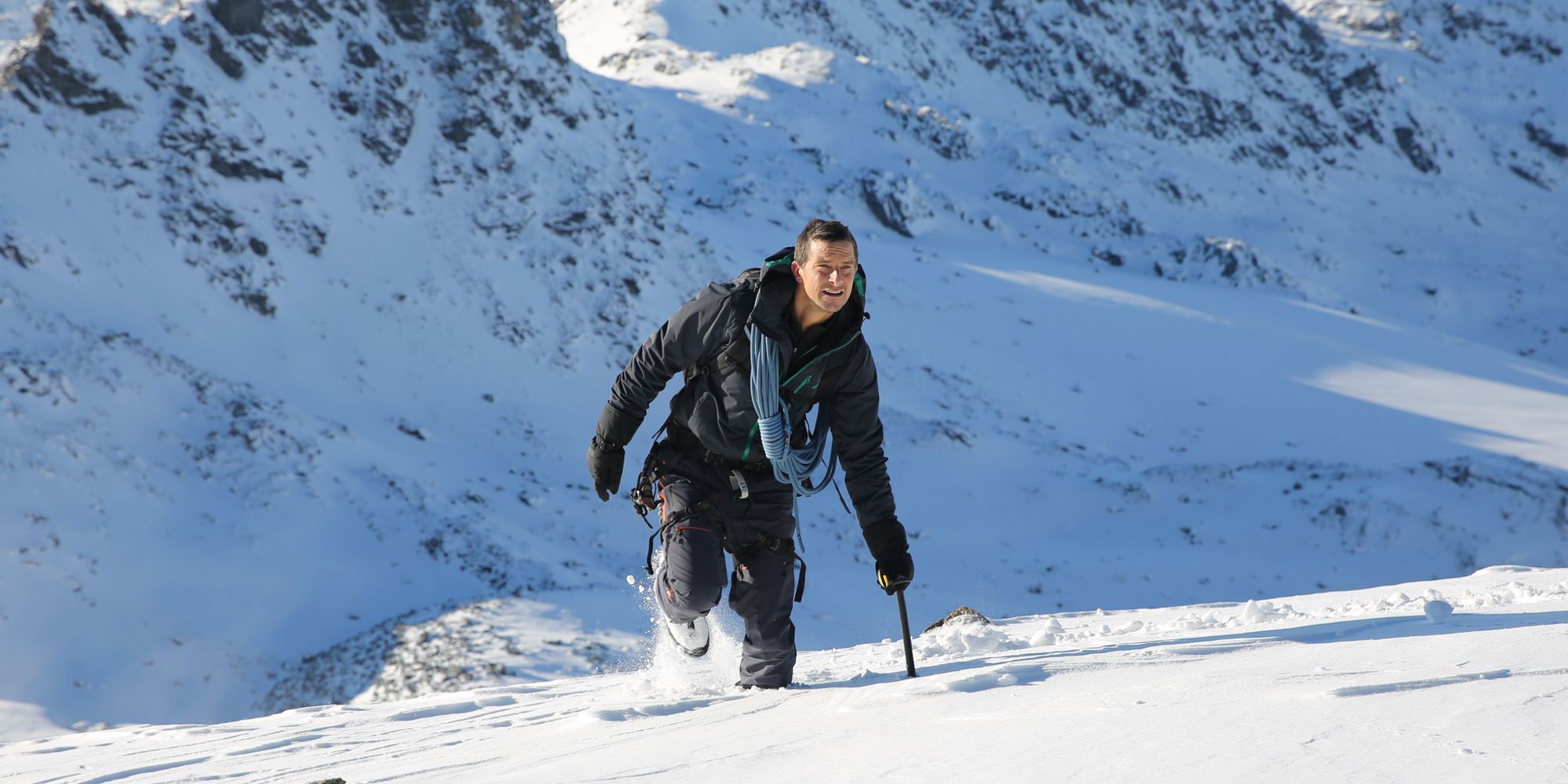Bear Grylls escalando na neve em Hostile Planet