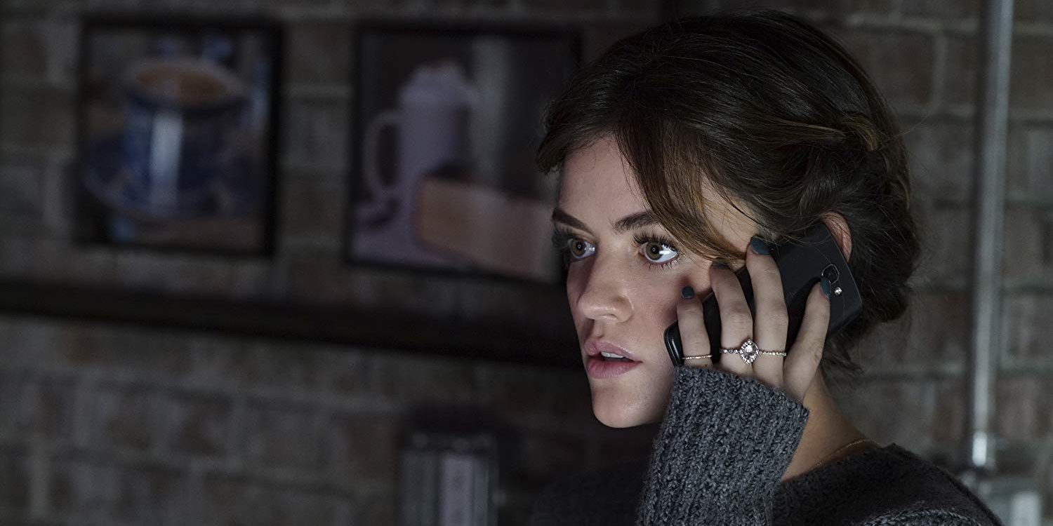 Lucy Hale holds a cell phone and looks shocked in Pretty Little Liars