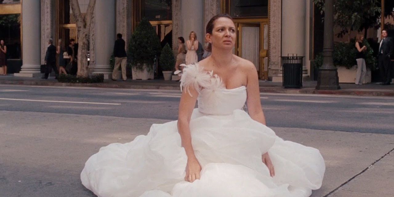 Maya Rudolph in a wedding dress sitting in the middle of the street with food poisoning in Bridesmaids