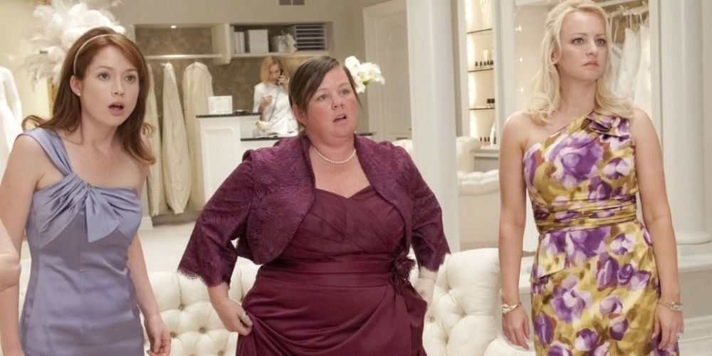 Melissa McCarthy, Ellie Kemper, and Wendi McLendon-Covey trying on dresses in Bridesmaids