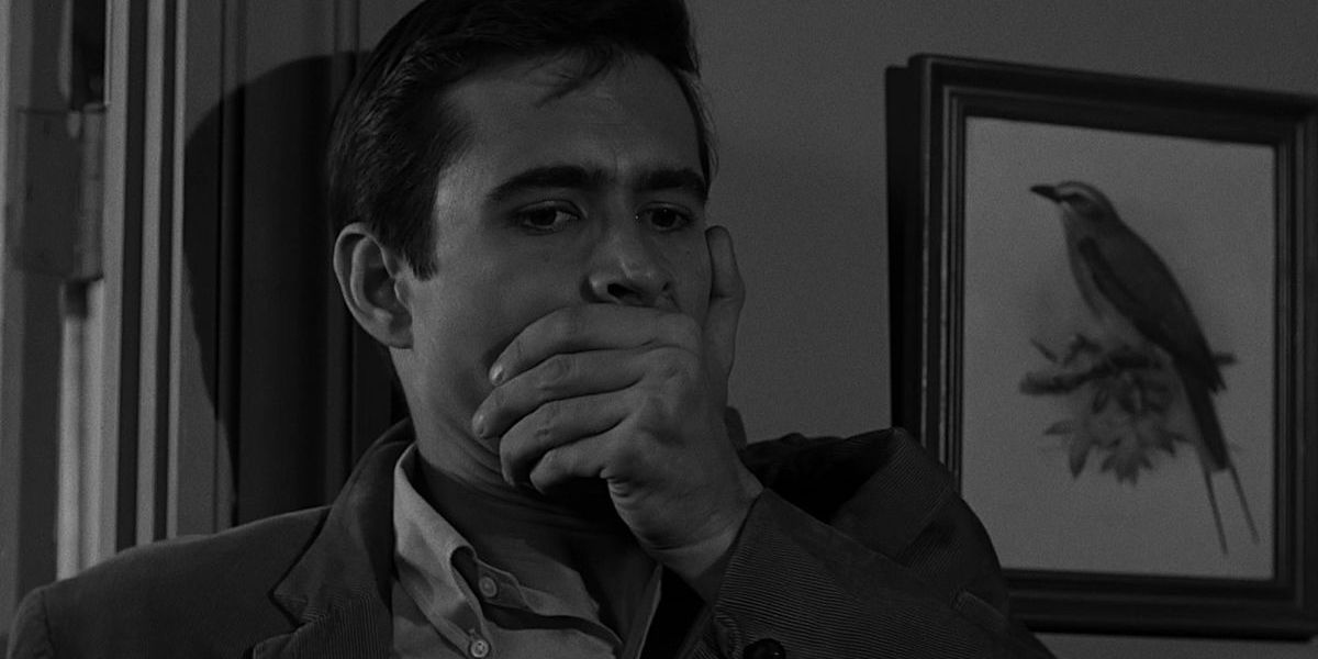 Norman Bates with his hand over his mouth in Psycho