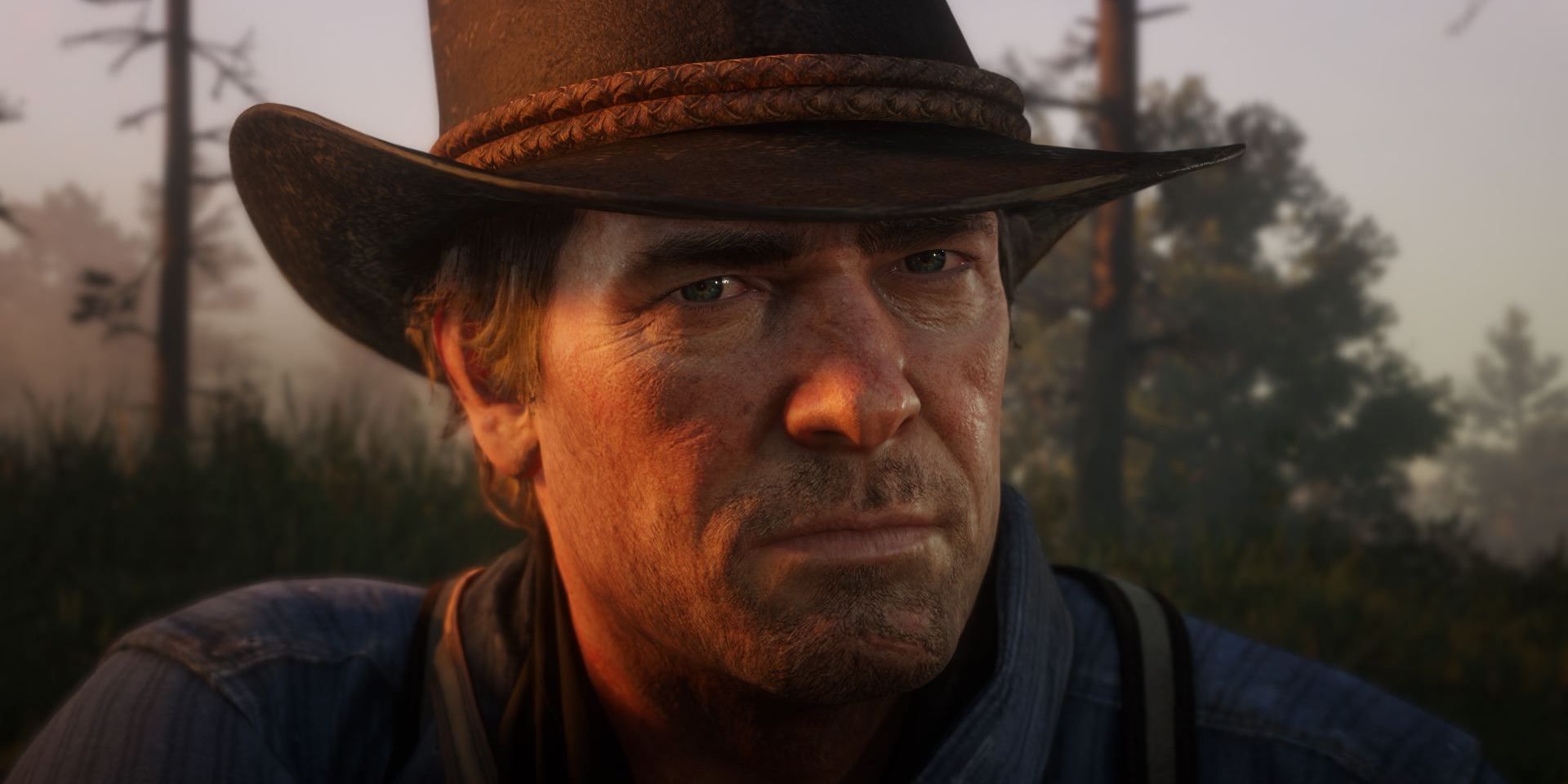 Arthur Morgan looking solemn in RDR2, the sun shining on his right side.