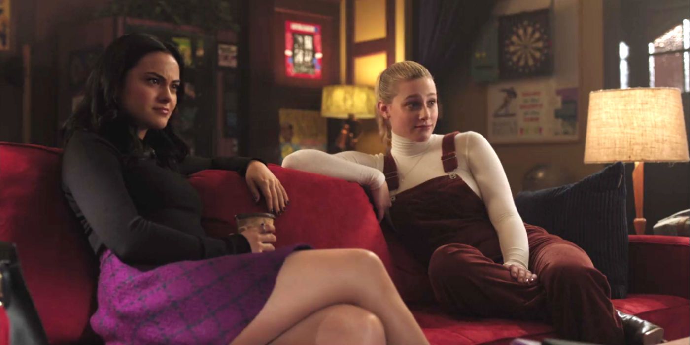 Betty and Veronica sit next to each other on a sofa