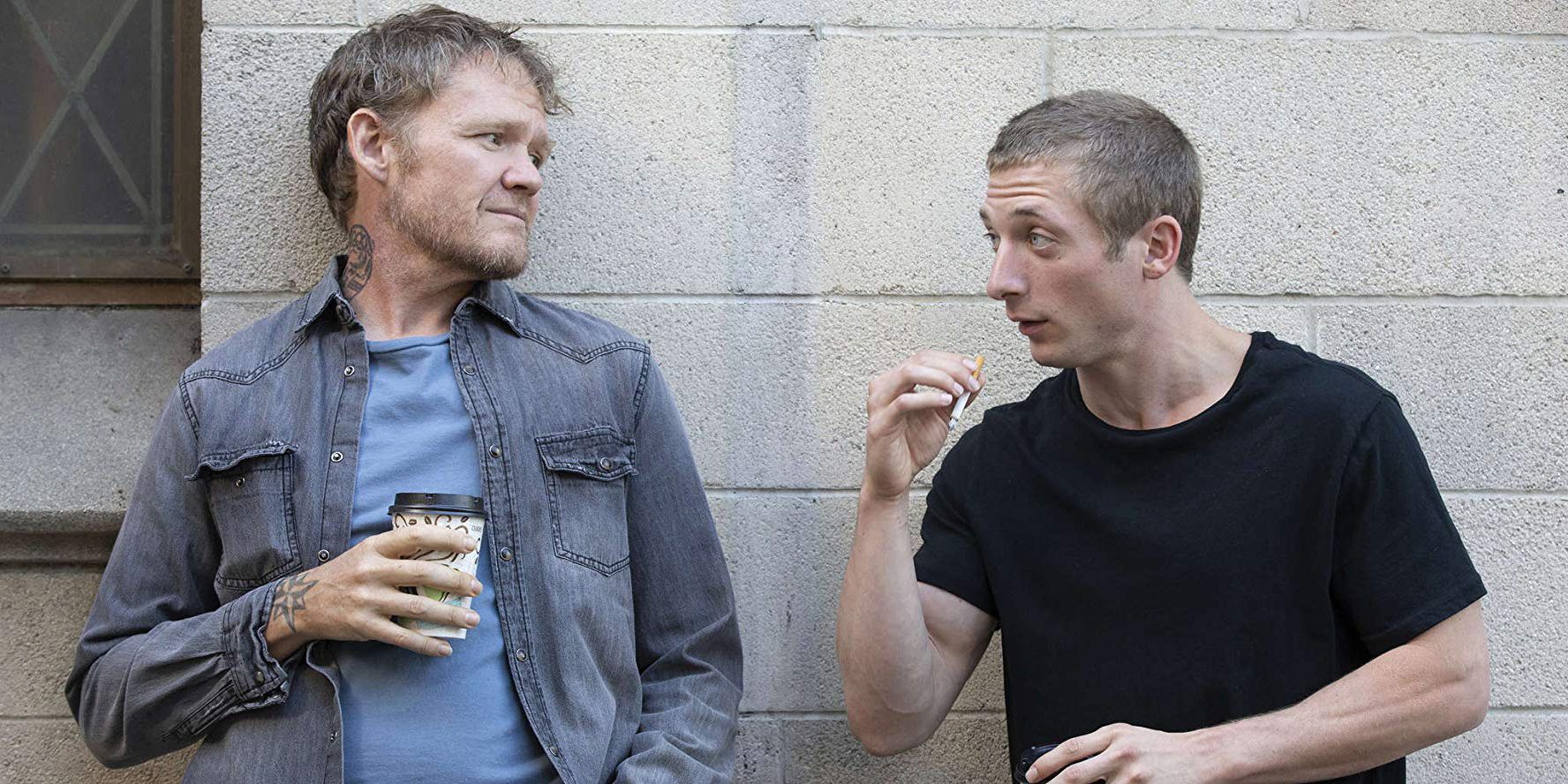 Brad holds a coffee while Lip talks to him outside of a building in Shameless U.S.