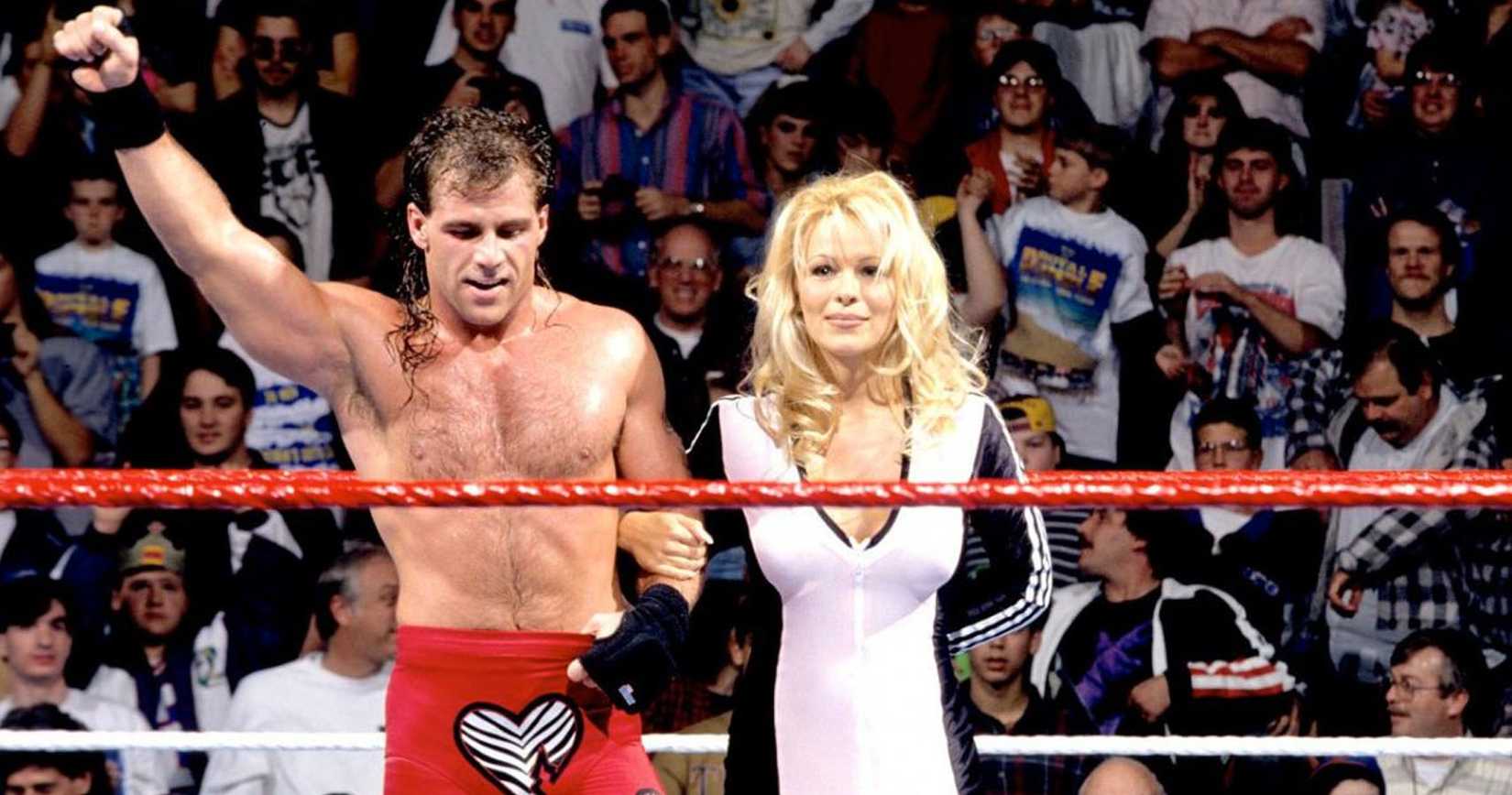 Shawn Michaels celebrates inside of a WWE ring with Pamela "Pam" Anderson