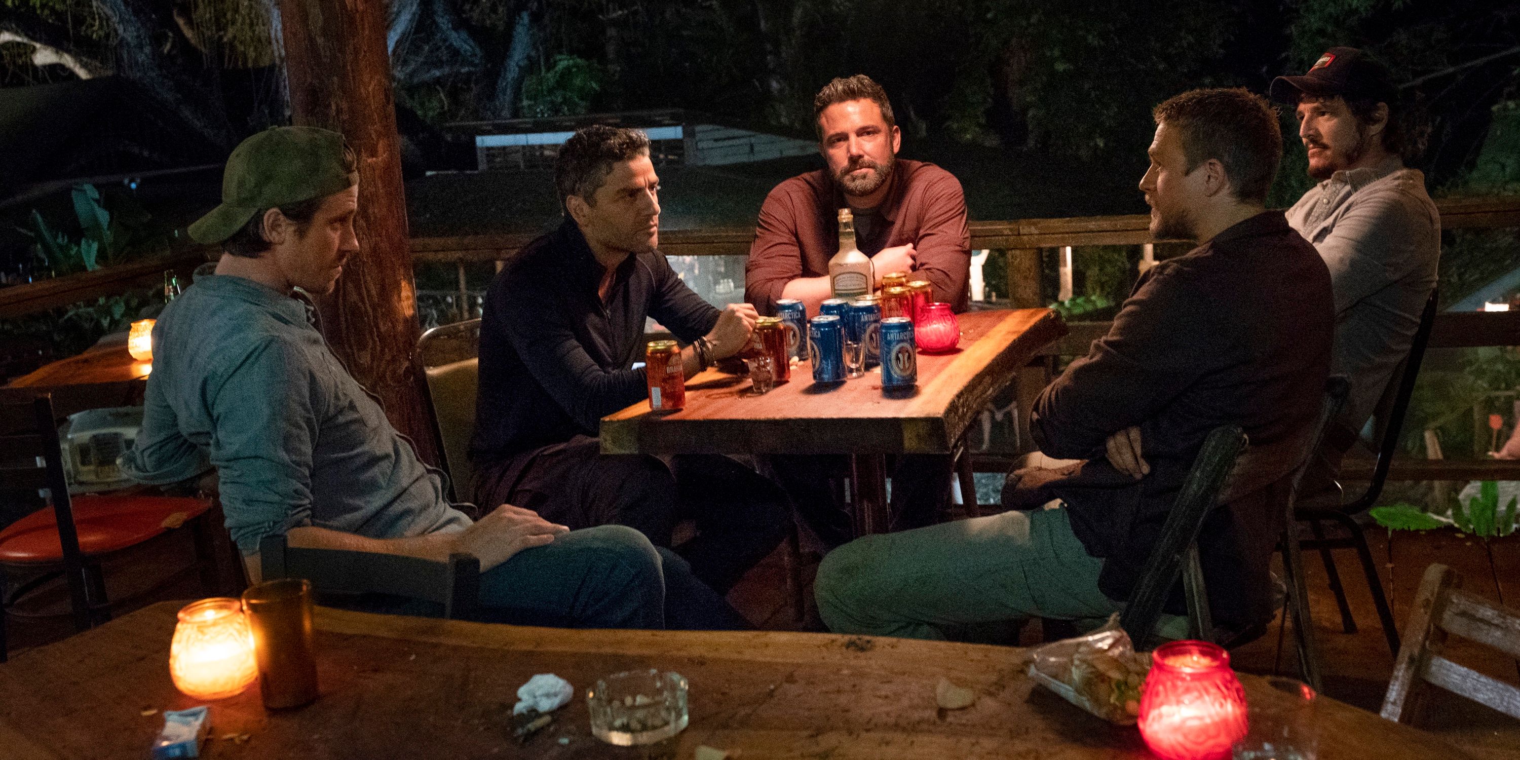 The main cast in Triple Frontier sitting around a table