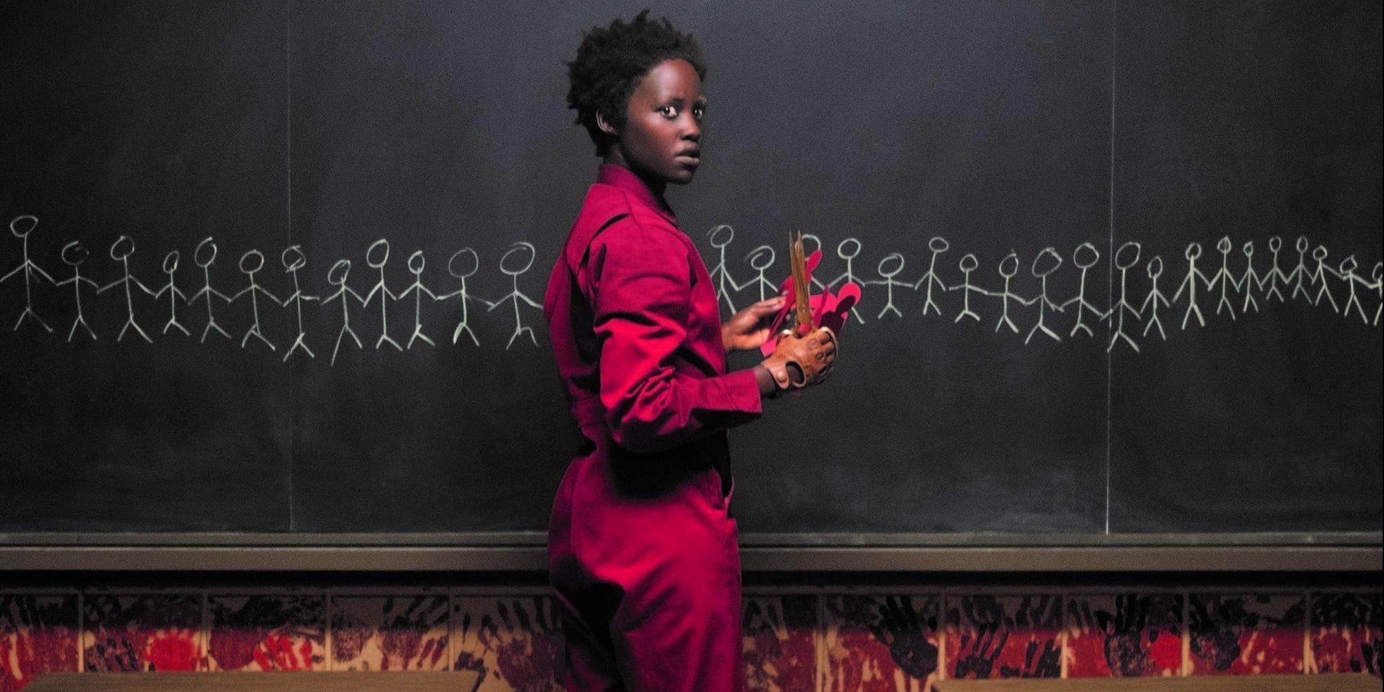 Lupita Nyong'o standing by a chalk board in Us