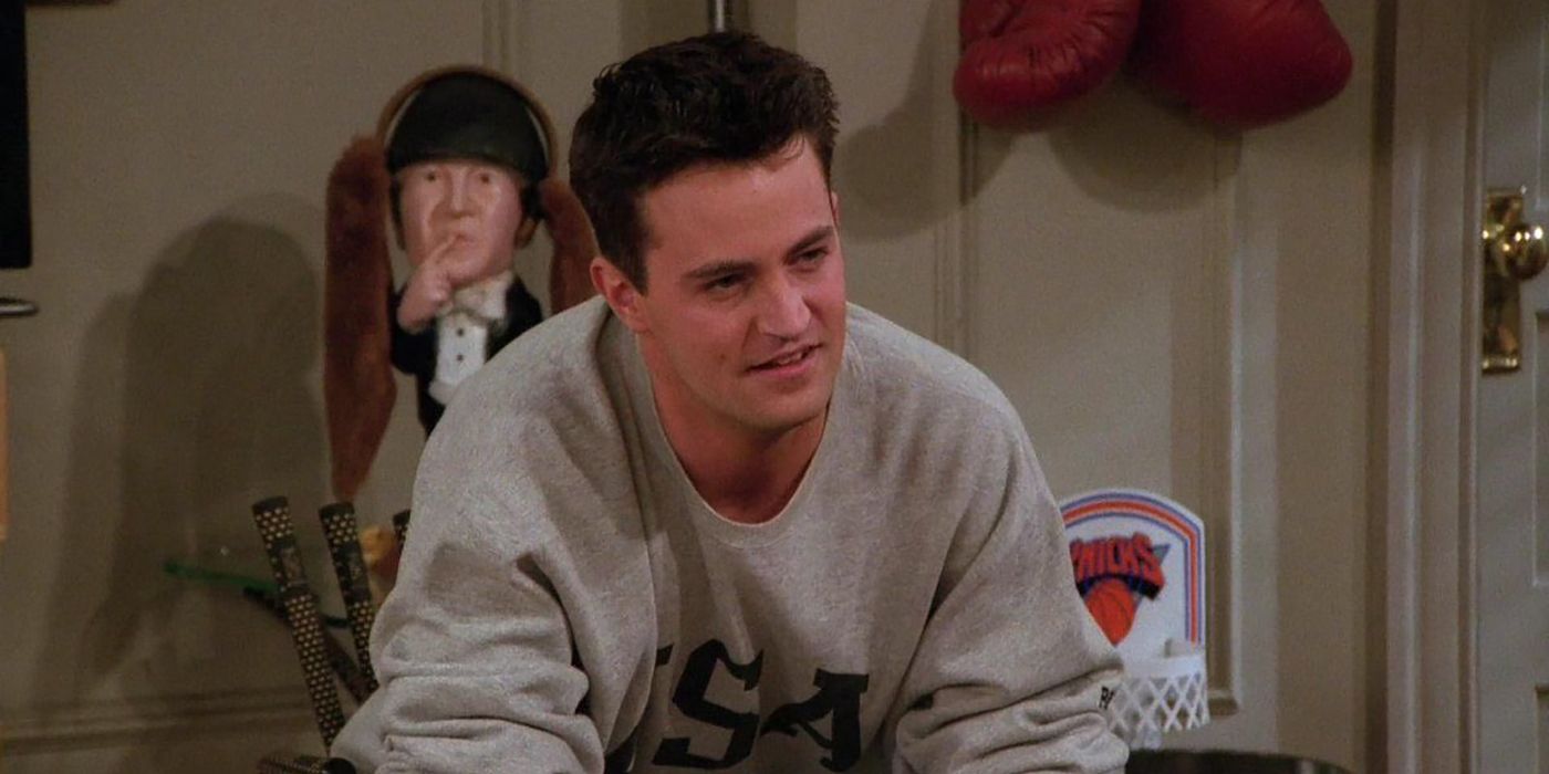 Chandler sitting down with a half smile on his face in Friends