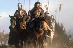 Orlando Bloom riding a horse through a battlefield in Kingdom of Heaven