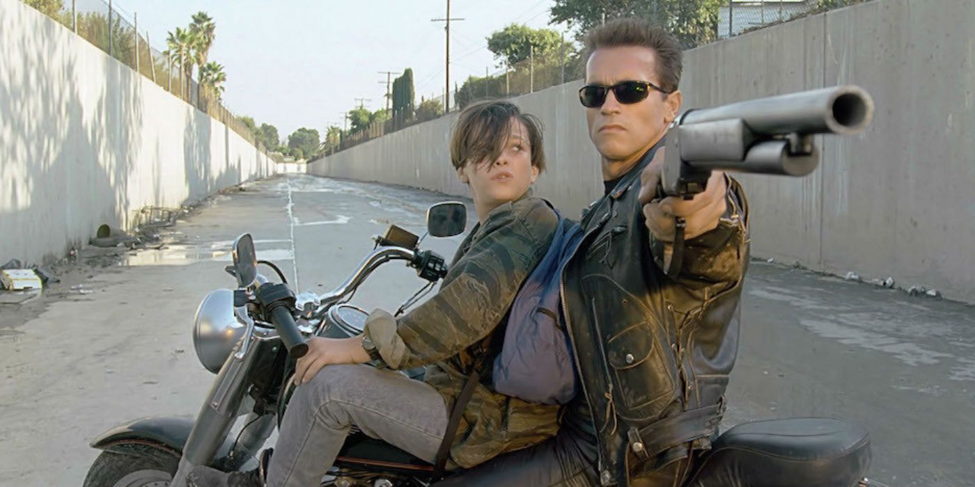 John Connor drives a bike while the T-800 points a gun in Terminator 2: Judgement Day