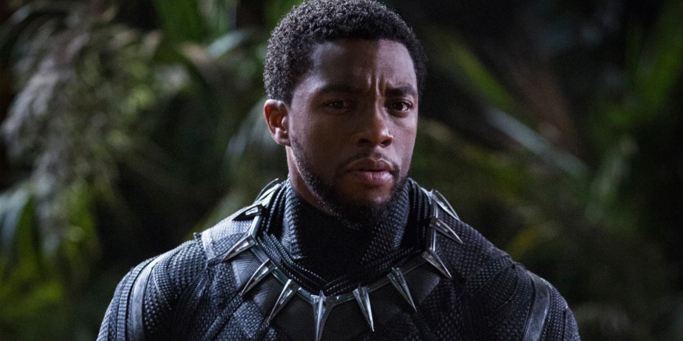 Chadwick Boseman as T'Challa standing in front of leaves in Black Panther