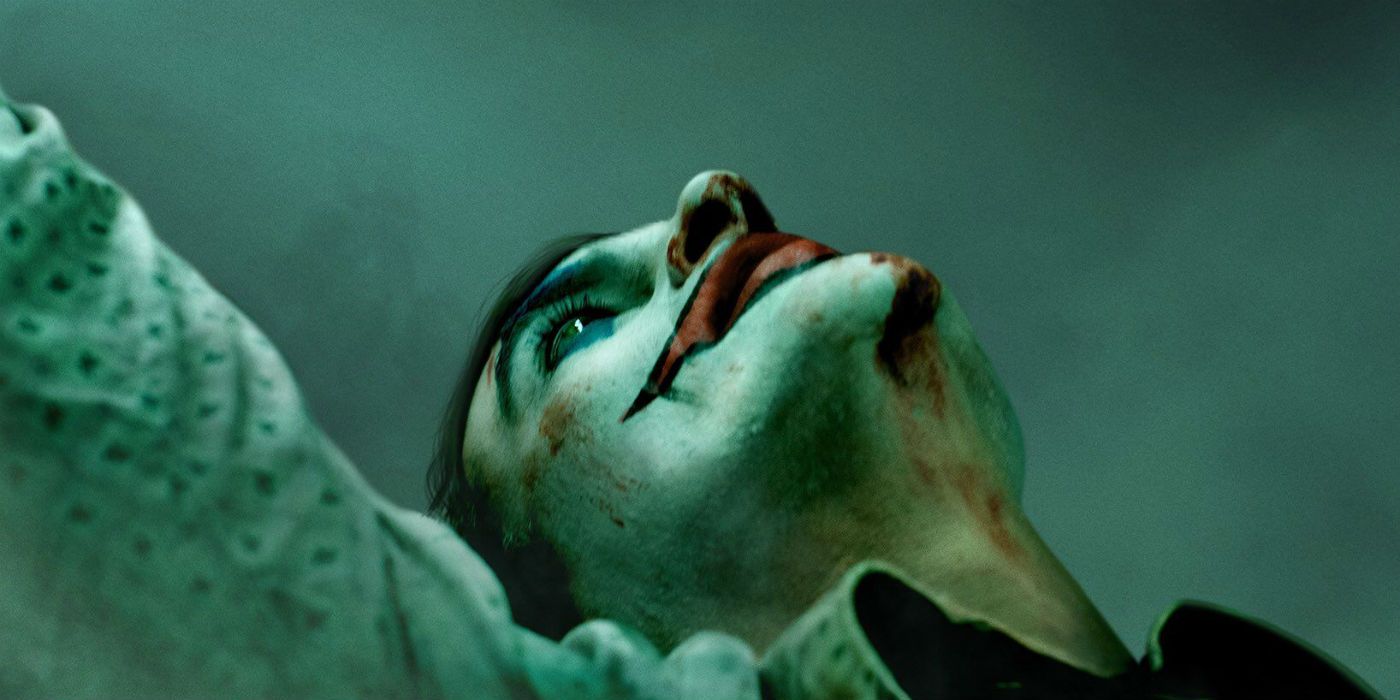Arthur Fleck leans back with blood on his face in a scene from Joker.