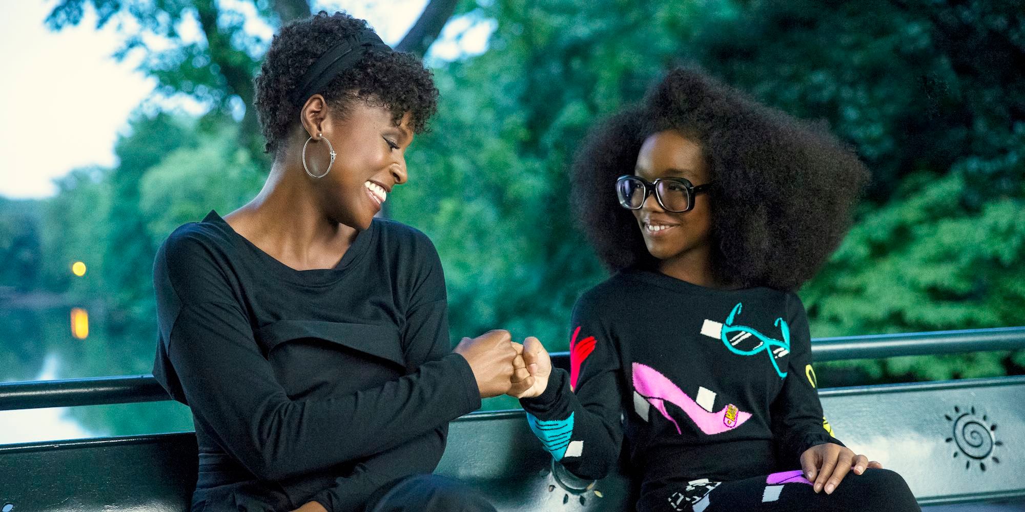 Issa Rae laughing and fist-bumping Marsai Martin in Little