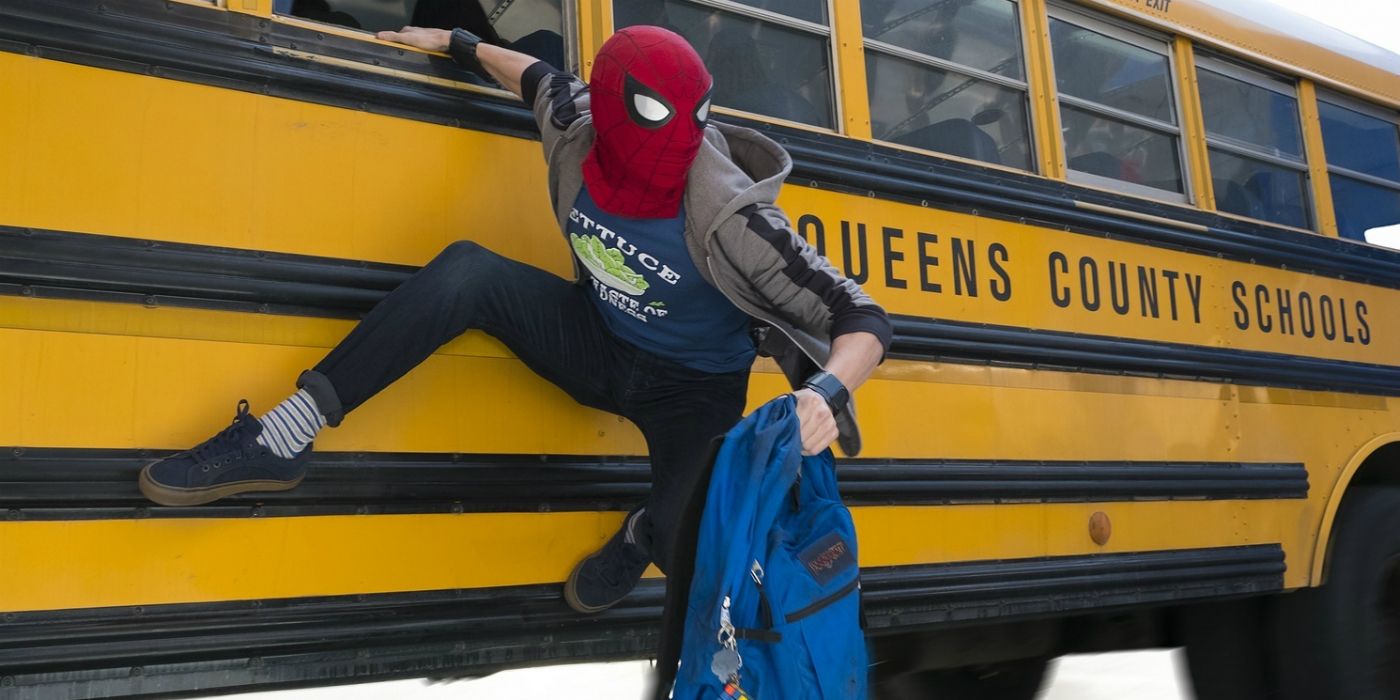 Spider-Man hangs on the side of a yellow school bus in Spider-Man: Homecoming.