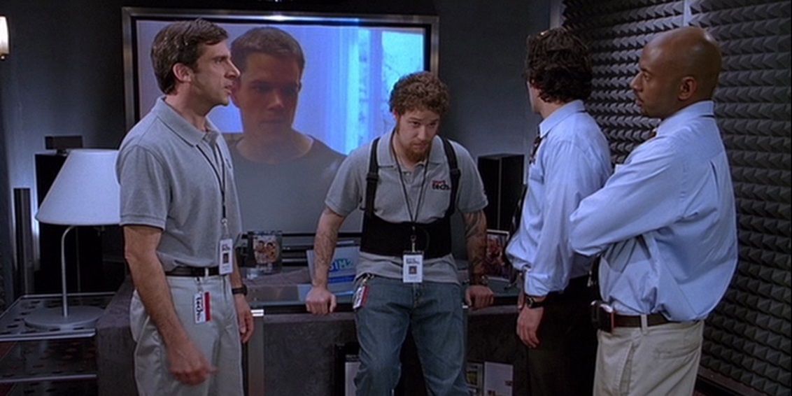 Andy, Cal, David and Jay talking in front of The Bourne Identity in The 40-Year-Old Virgin