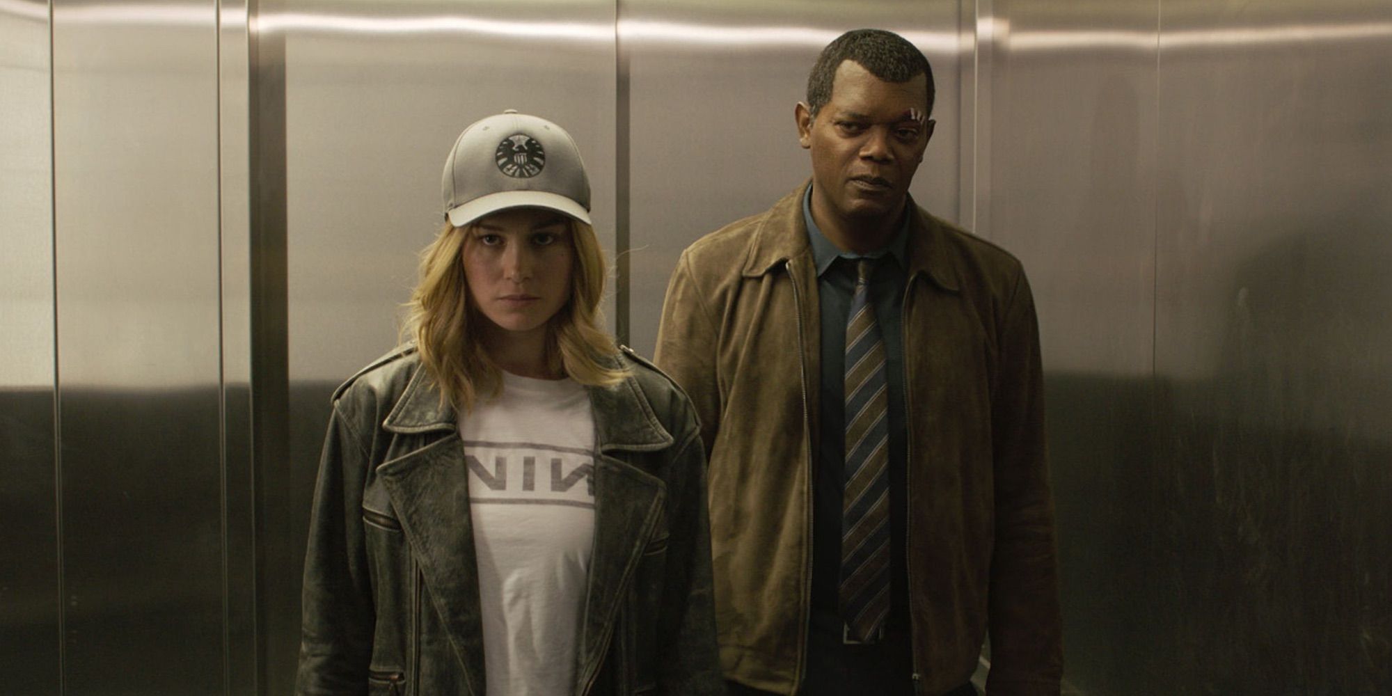 Carol Danvers with cap on with Nick Fury in elevator