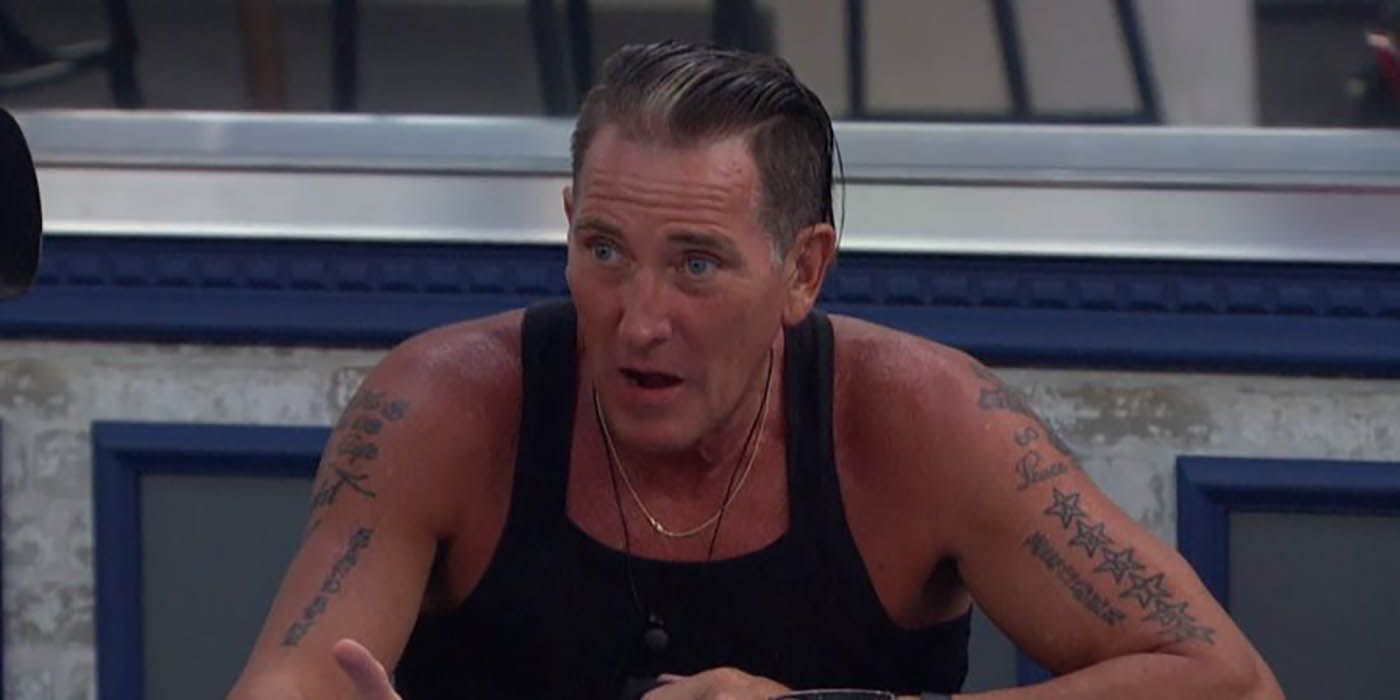 Kevin from Big Brother sitting in a chair, wearing a black tank top, tattoos visible on his arms.