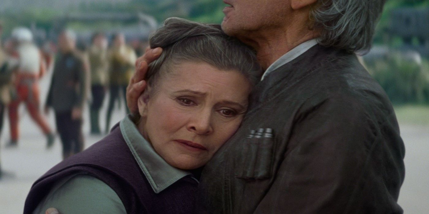 Han Solo holds a mournful Leia Organa's head tenderly against his chest.