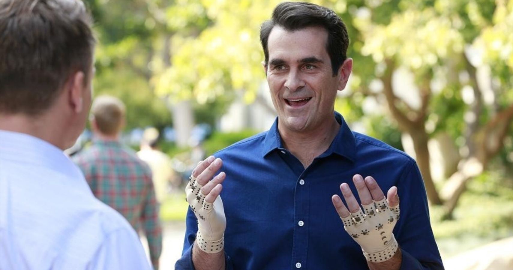 Modern Family - Phil Dunphy showing off his hand gloves on TV