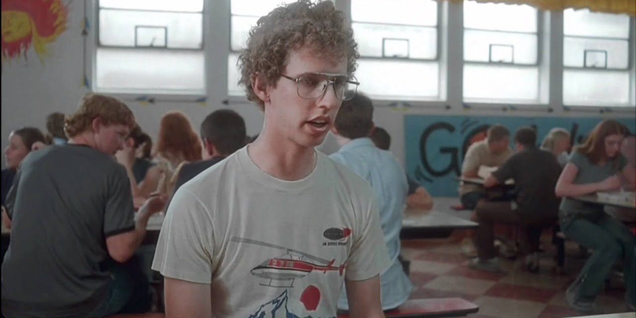 Napoleon sitting at a table in the cafeteria in Napoleon Dynamite