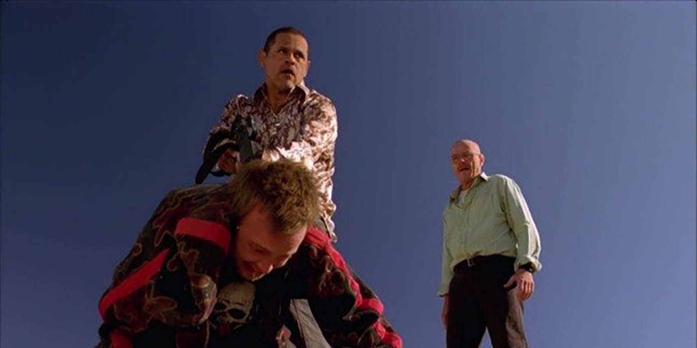 Tuco holding a gun to Jesse's head in a scene from Breaking Bad, Walt looking on from behind.