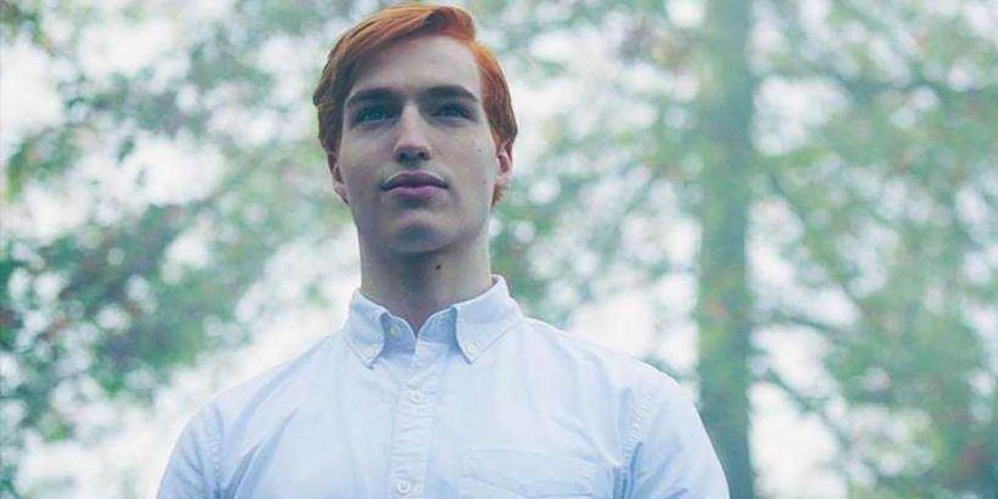 Jason Blossom standing in a forest on Riverdale