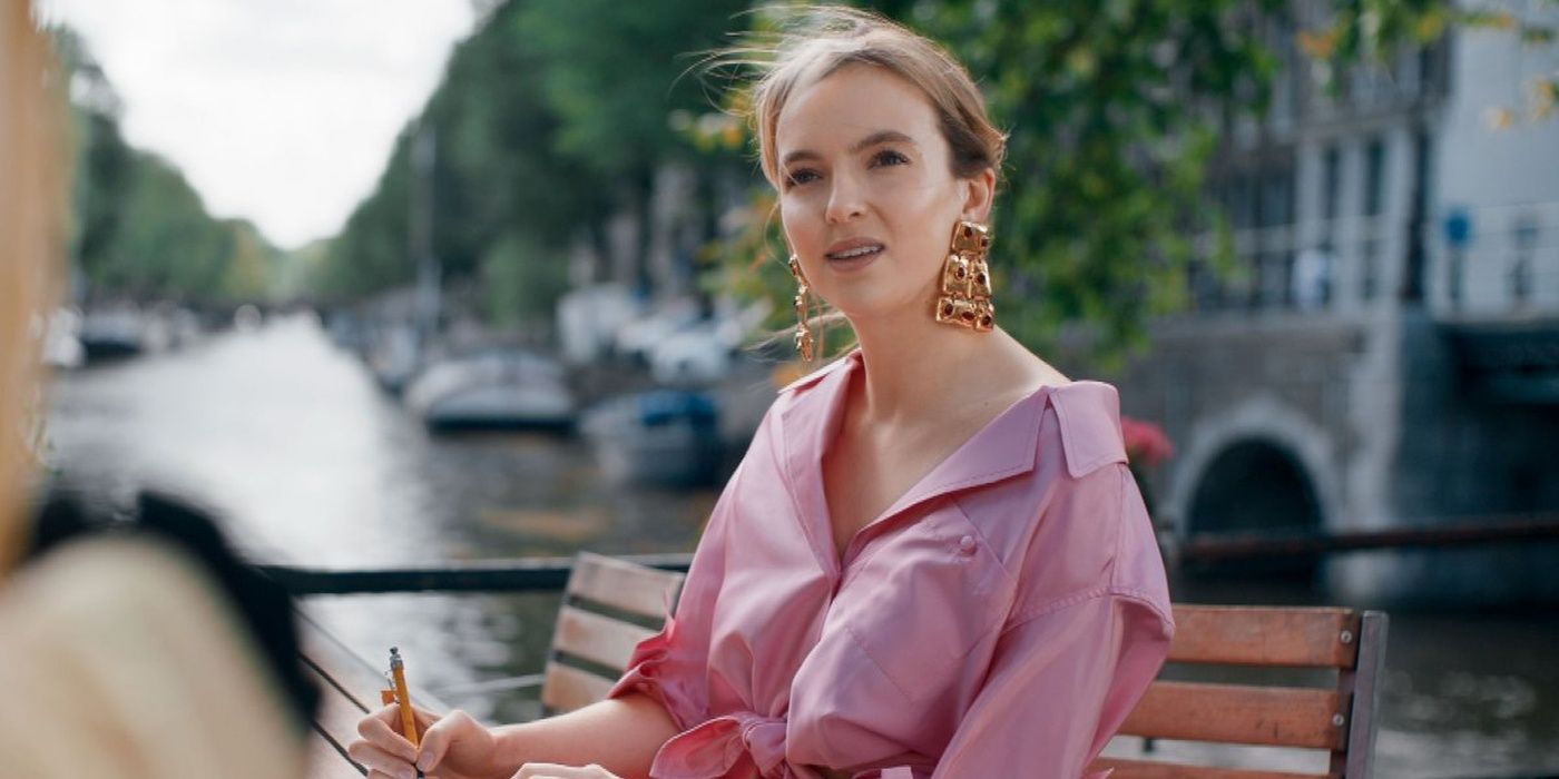 Villanelle sitting on a bench in a pink dress in Killing Eve