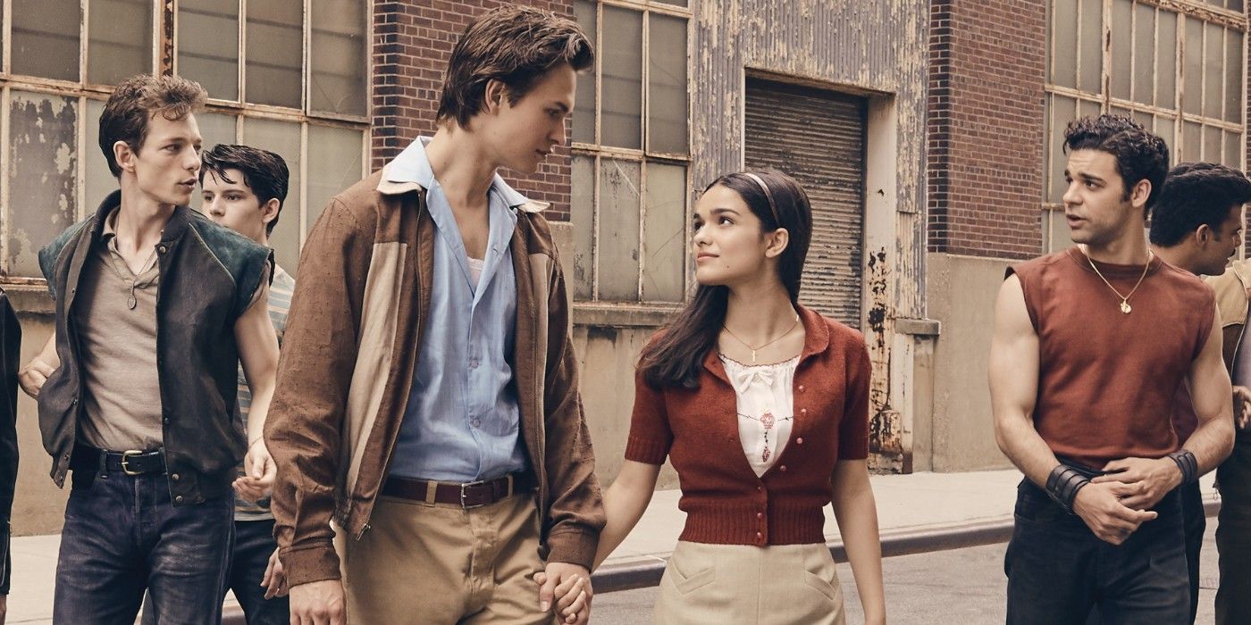 Ansel Elgort and Rachel Zegler hold hands in front of the rival gangs in West Side Story 2021